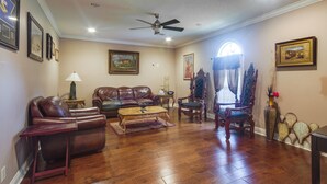 A living room with a leather sofa, a wooden coffee table, and a fireplace. - Homey Greenwood Getaway w/ Patio & Backyard (Greenwood)