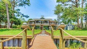 A wooden bridge leading to a house with a green roof and a front porch. - Waterfront Florida Vacation Rental w/ Boat Dock (Milton)