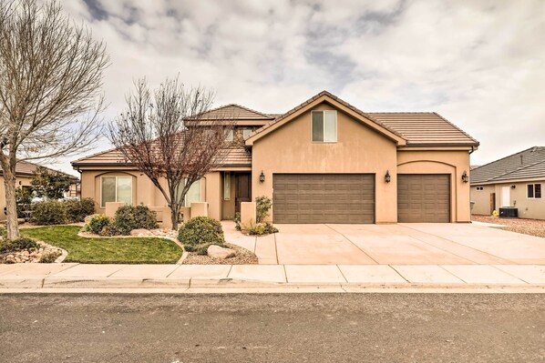 A single-story house with a garage, a driveway, and a well-maintained lawn.
