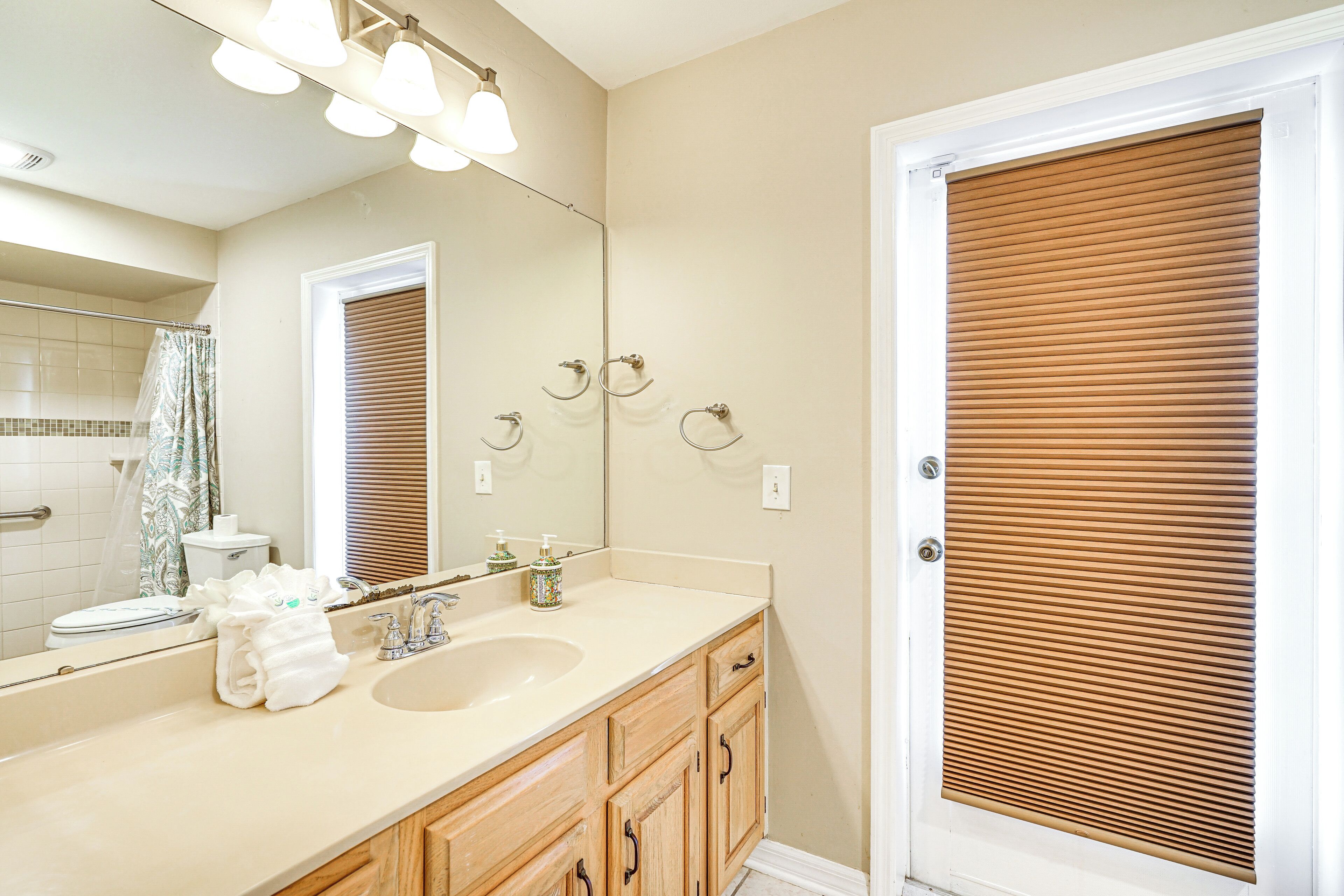A bathroom with a sink, mirror, and wooden cabinets.