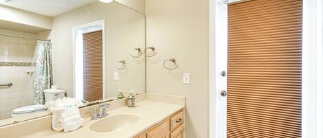 A bathroom with a sink, mirror, and wooden cabinets.