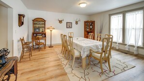 A dining room with a wooden table, chairs, a chandelier, and a fireplace. - Charming Stevensville Home w/ Open Yard! (Stevensville)