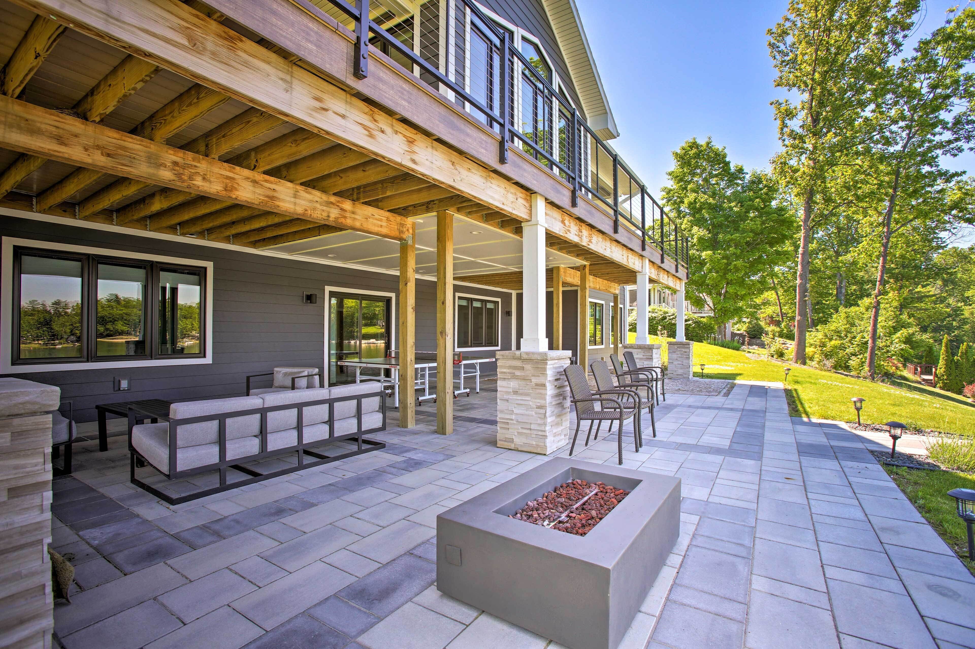 A covered patio area with outdoor seating, a fire feature, and a view of the surrounding landscape.