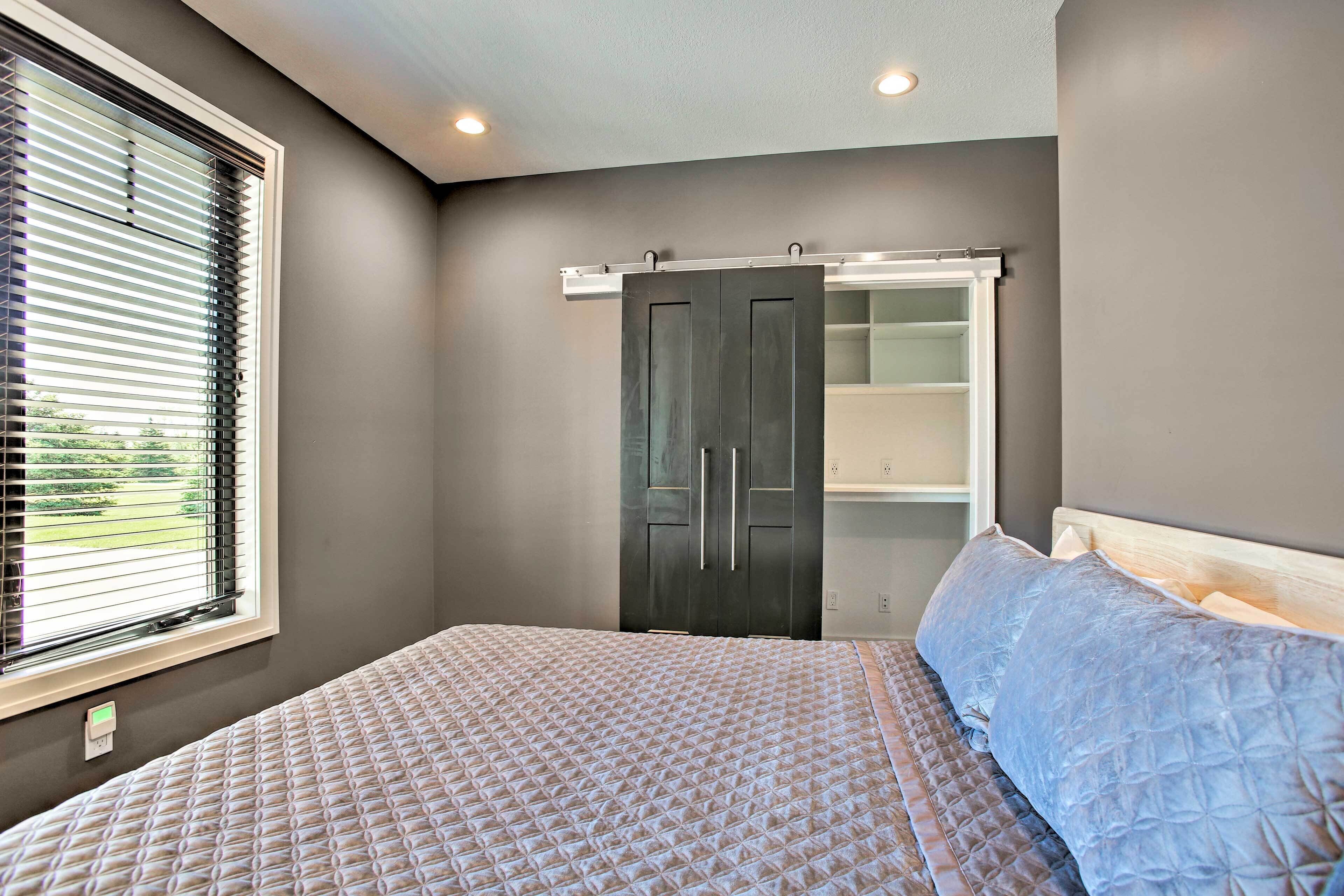 Une chambre à coucher avec un lit, une armoire et une fenêtre équipée de stores.