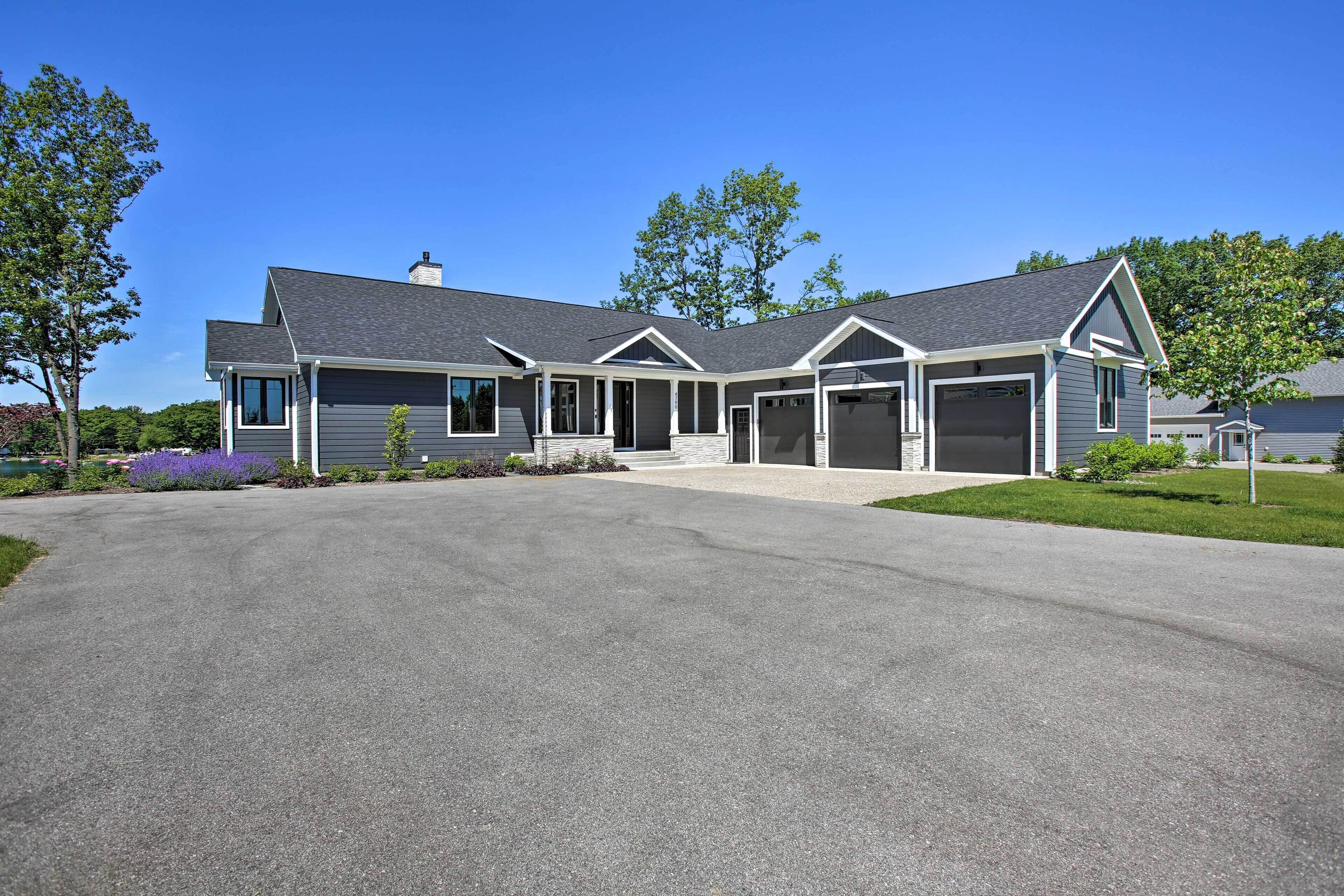 A modern two-story house with a covered garage, a front porch, and a driveway.