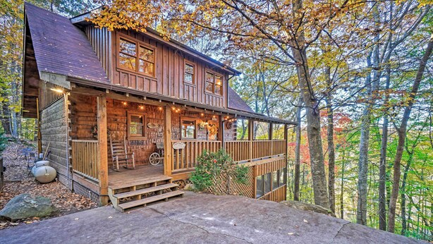 Ein rustikales Blockhaus mit Veranda, Holzstufen und einem Steinfundament.