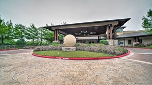 A building entrance with a large spherical sculpture, hexagonal paving, and a red curb marking a fire lane and parking area. - Lovely Montgomery Retreat w/ Patio & Yard! (Montgomery)