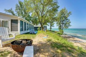 A beach house with a fire pit, outdoor seating, and a view of the ocean. - Sunny Mears Vacation Rental w/ Private Beach! (Mears)