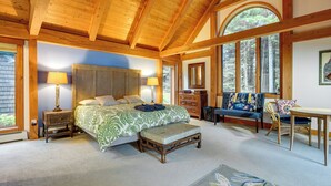 A bedroom with a large bed, wooden ceiling beams, a bench, a dresser, and a chair. - Lakefront Paradise Near Okemo & Killington (Mount Holly)