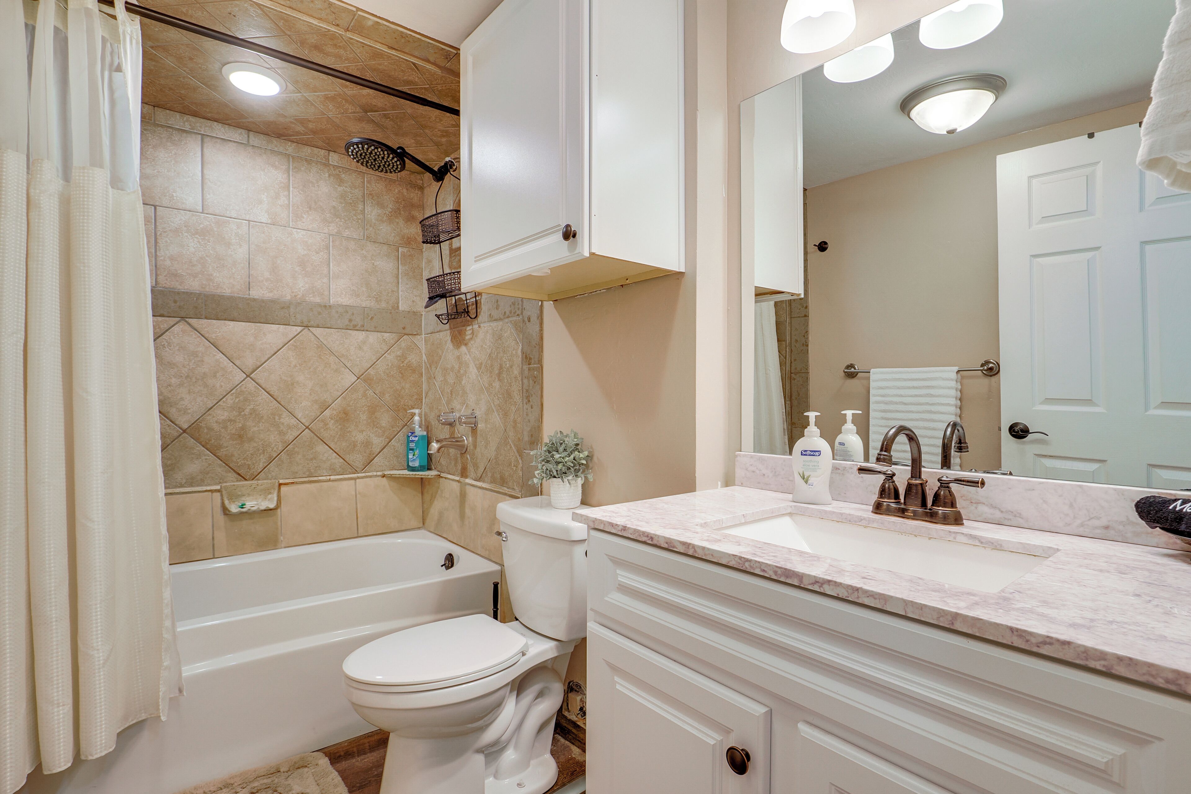 A bathroom with a bathtub, toilet, and sink.