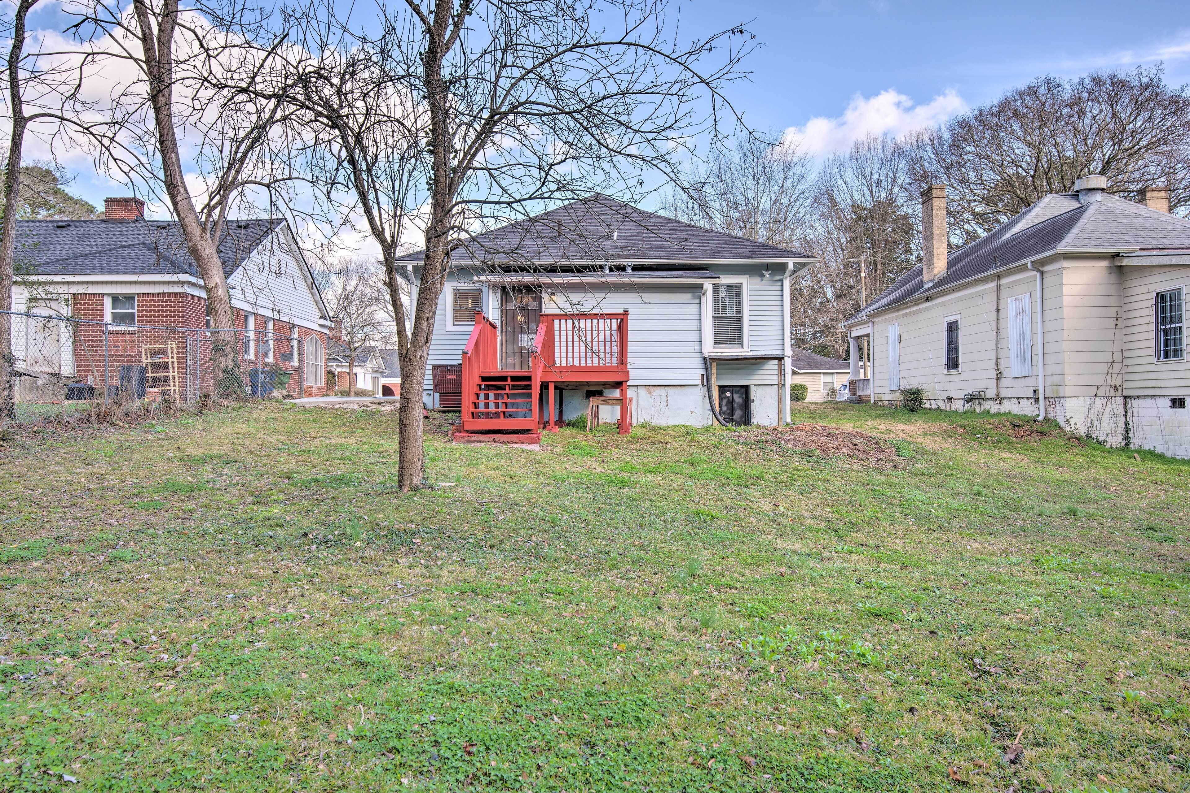 A residential area with houses, a red deck, and a grassy yard.