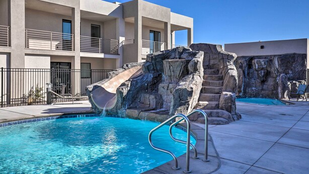 A modern hotel with a pool area featuring a rock waterfall and a metal pool ladder. - Gorgeous St George Condo w/ Community Pool! (St. George)