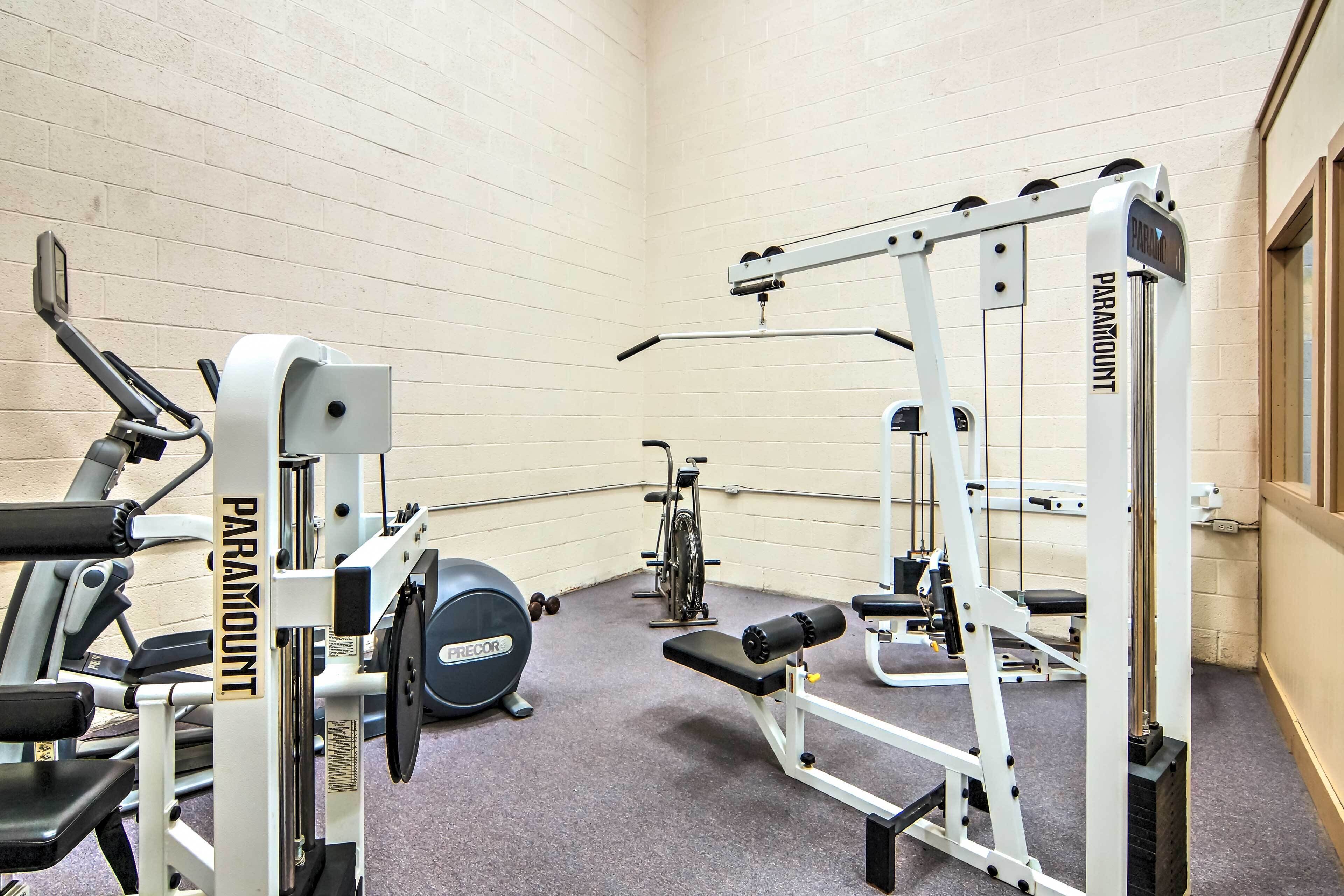 Ein Fitnessstudio mit verschiedenen Trainingsgeräten, darunter ein Squat-Rack, eine Langhantelbank und Kraftgeräte.
