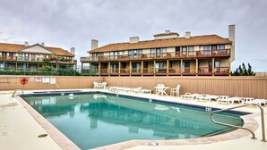 Ein Hotel mit Swimmingpool, mehreren Balkonen und Außenbereichen zum Sitzen.