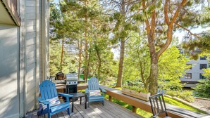 A wooden deck with outdoor furniture, a grill, and a view of trees and a building. - All-season Sun Valley Retreat w/ Deck & Grill (Sun Valley)
