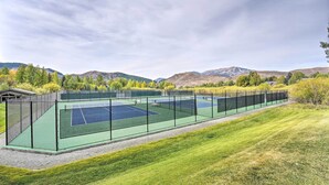 A tennis court with a net, surrounded by a fence and a grassy area. - All-season Sun Valley Retreat w/ Deck & Grill (Sun Valley)