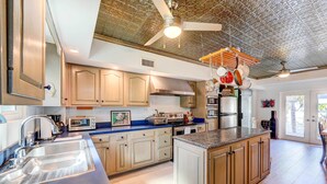 A modern kitchen with wooden cabinets, stainless steel appliances, and a large island. - Canal-front Florida Keys Home w/ Dock! (Tavernier)