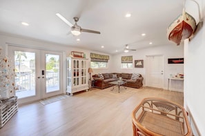 Relax in this inviting living room with a high ceiling, ceiling fans, and comfortable seating for two.