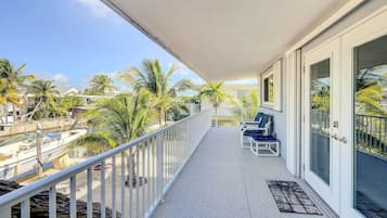 Enjoy a tranquil view of the marina from this balcony with seating for two.