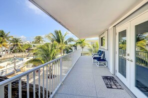 Enjoy a tranquil view of the marina from this balcony with seating for two.