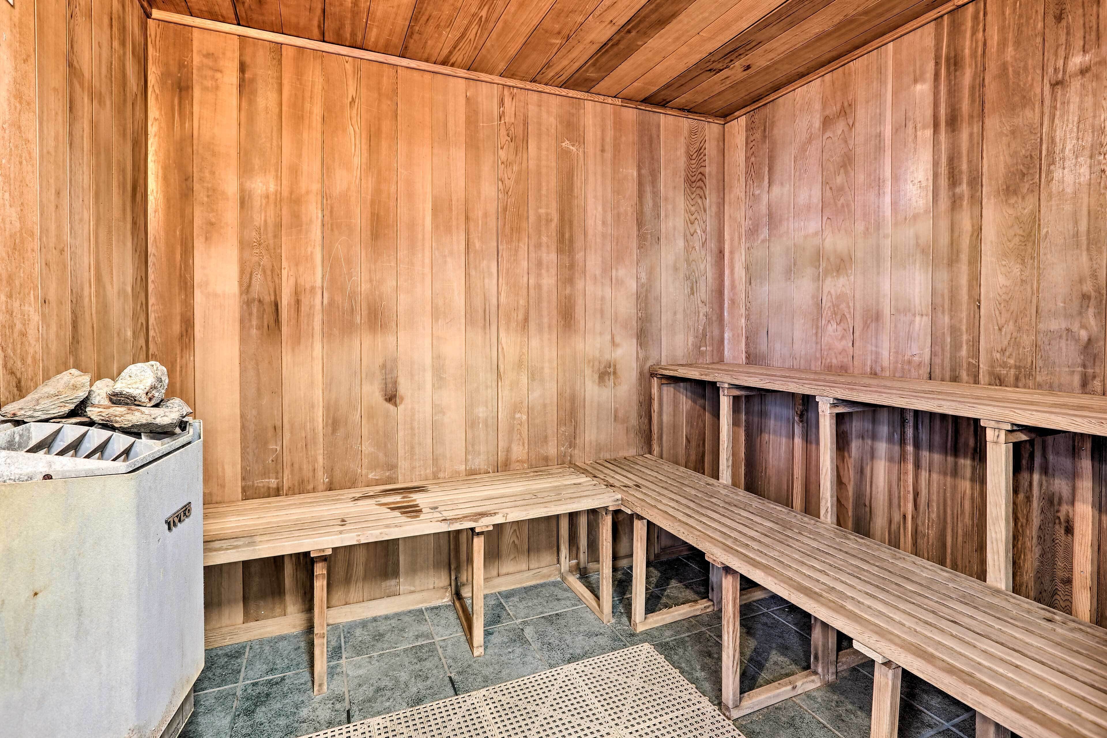 A sauna with wooden benches and a stone heater.