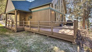 A wooden cabin with a deck, large windows, and a covered porch. - Klamath Falls Cabin Retreat w/ Deck & Grill! (Klamath Falls)