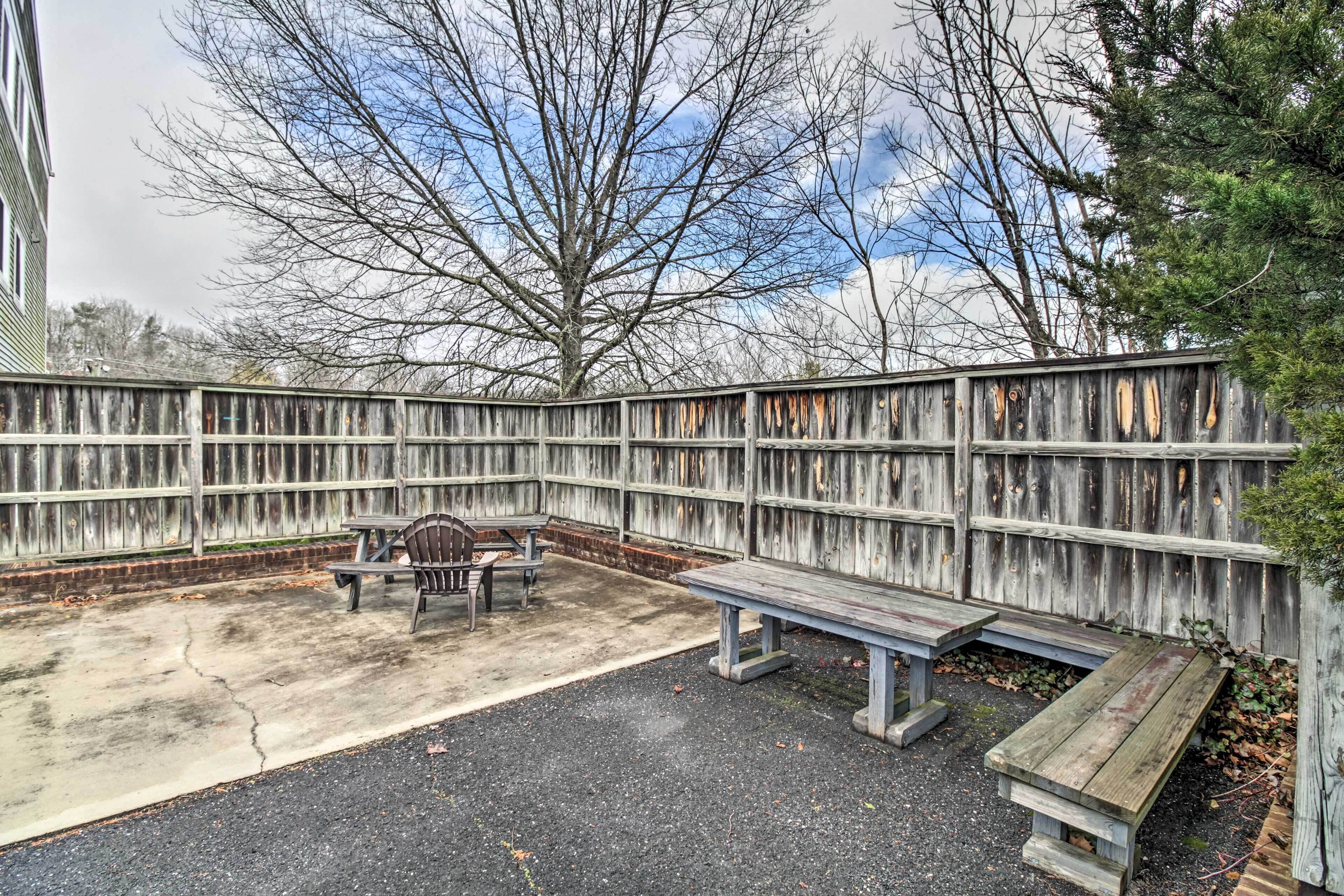 A fenced outdoor area with a bench and picnic table.