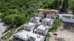 Un immeuble à plusieurs étages doté d’un bar sur le toit et d’un espace extérieur aménagé pour s’asseoir.