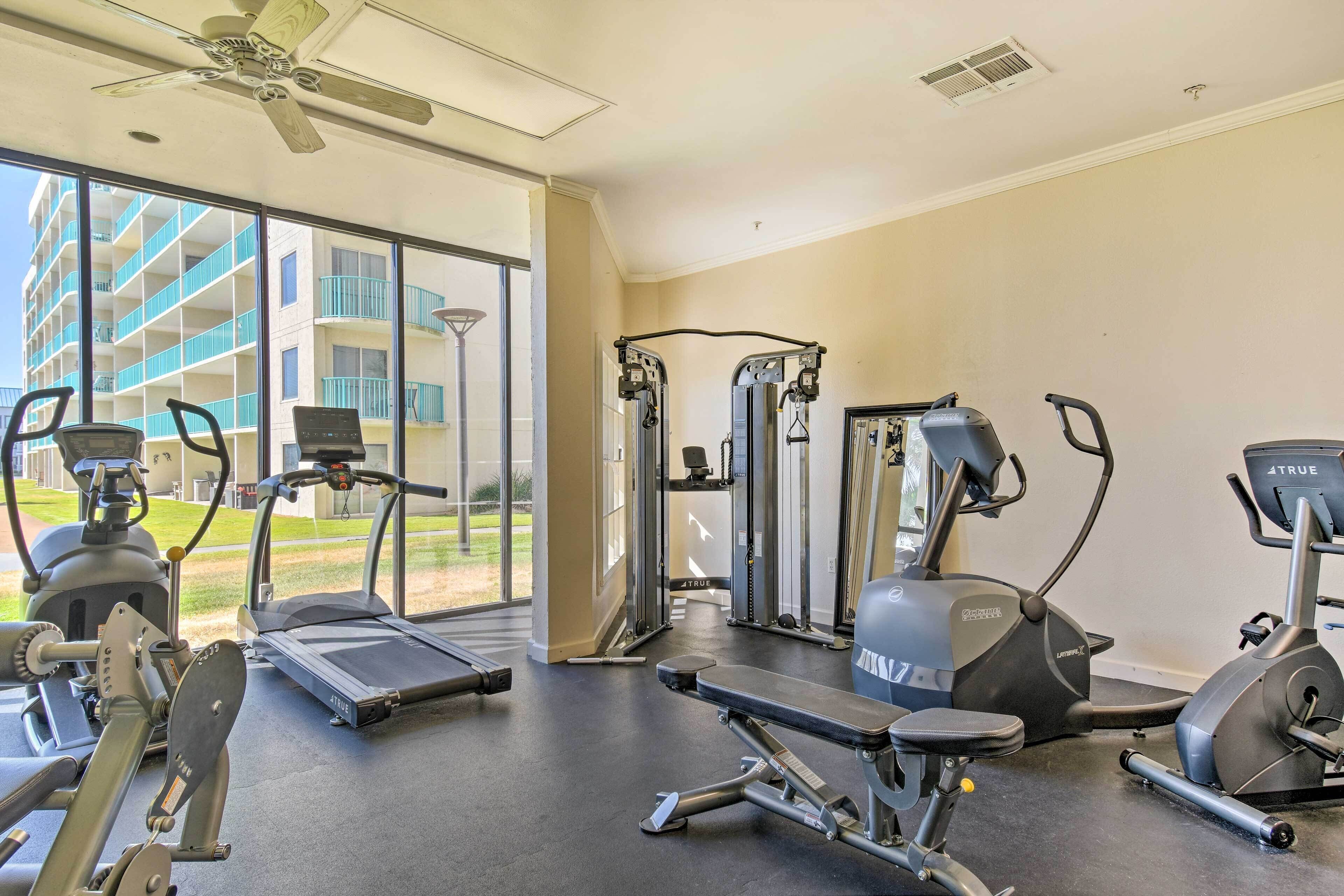 A gym with treadmills, weight machines, and a rowing machine.