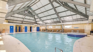 Piscina interior con techo alto y zona de hidromasaje.