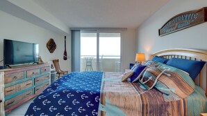 A bedroom with a large bed, a television, a wooden dresser, and a sign above the bed that reads "Gulf Atlantic Charter Yacht Rental." - Gulf-front Views: Coastal Hudson Condo! (Hudson)