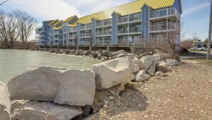 A multi-story hotel with balconies, located near a body of water. - Waterfront Middle Bass Condo w/ Lake Erie Views! (Put-in-Bay)