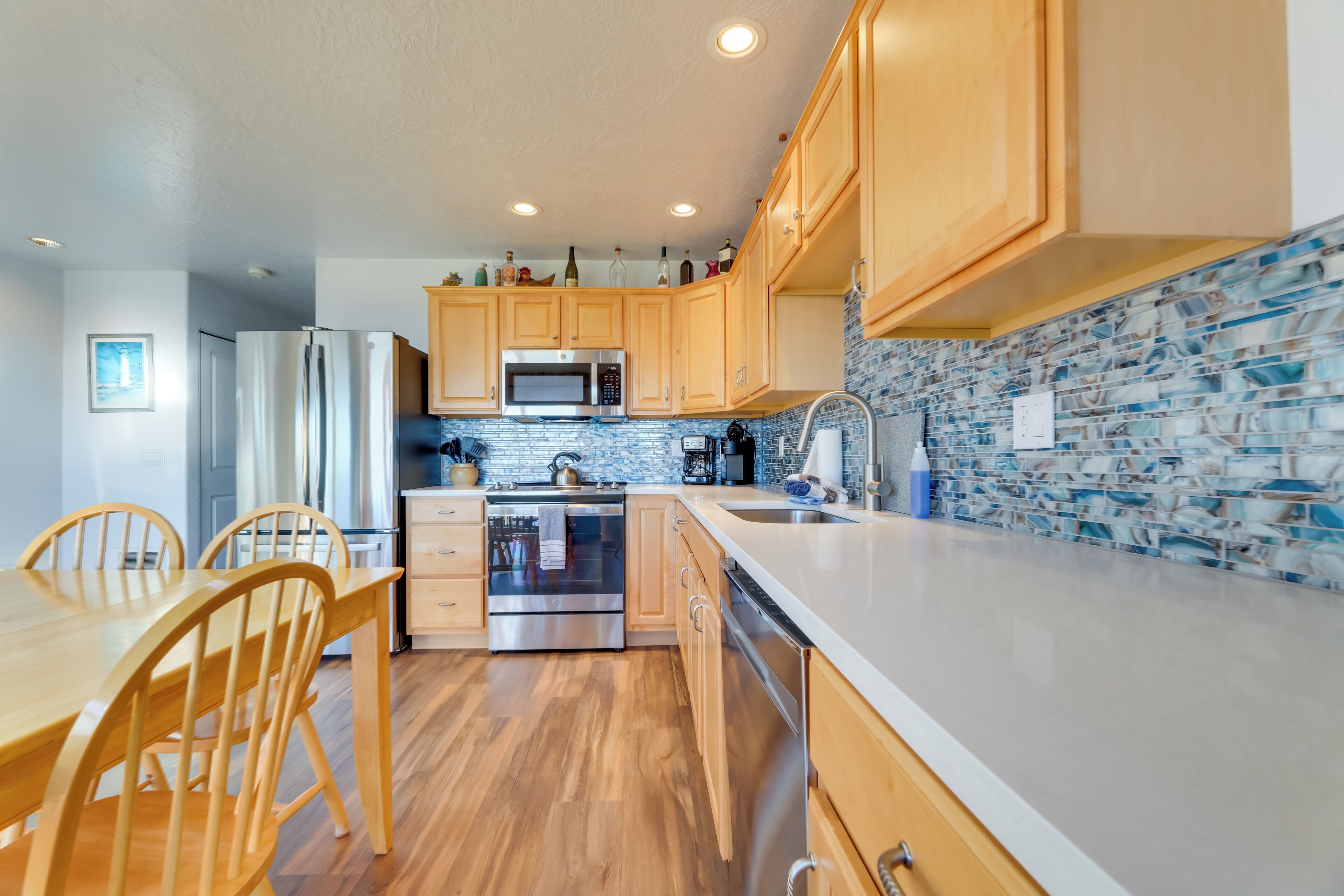 A modern kitchen with wooden cabinets, stainless steel appliances, and a tiled backsplash.