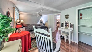 A bedroom with a bed, a desk, a chair, a ceiling fan, and a bookshelf. - Cloudcroft Cabin w/ National Forest Views! (Cloudcroft)