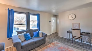 A modern living room with a gray sofa, a small desk, and a chair. - Family-friendly Rockford Home w/ Private Yard! (Rockford)