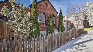 A brick building with a large arched window and a wooden fence in front. - Ski, Shop & Explore: Walkable Midtown Reno Oasis! (Reno)