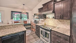 Een moderne keuken met donkere houten kasten, granieten werkbladen, een ingebouwde oven en een plafondventilator.