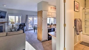 Une cuisine moderne avec des meubles blancs, un four encastré et un coin repas comprenant une table et des chaises.