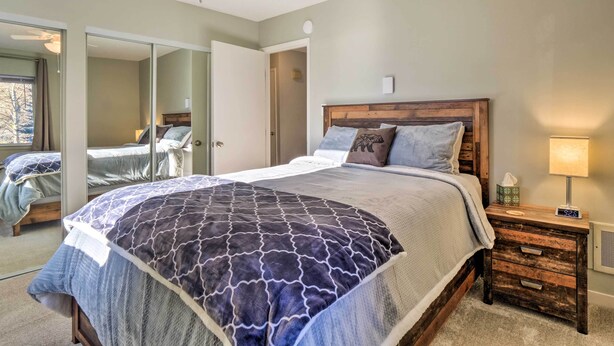 Une chambre à coucher avec un grand lit, une table de chevet avec une lampe et un miroir.