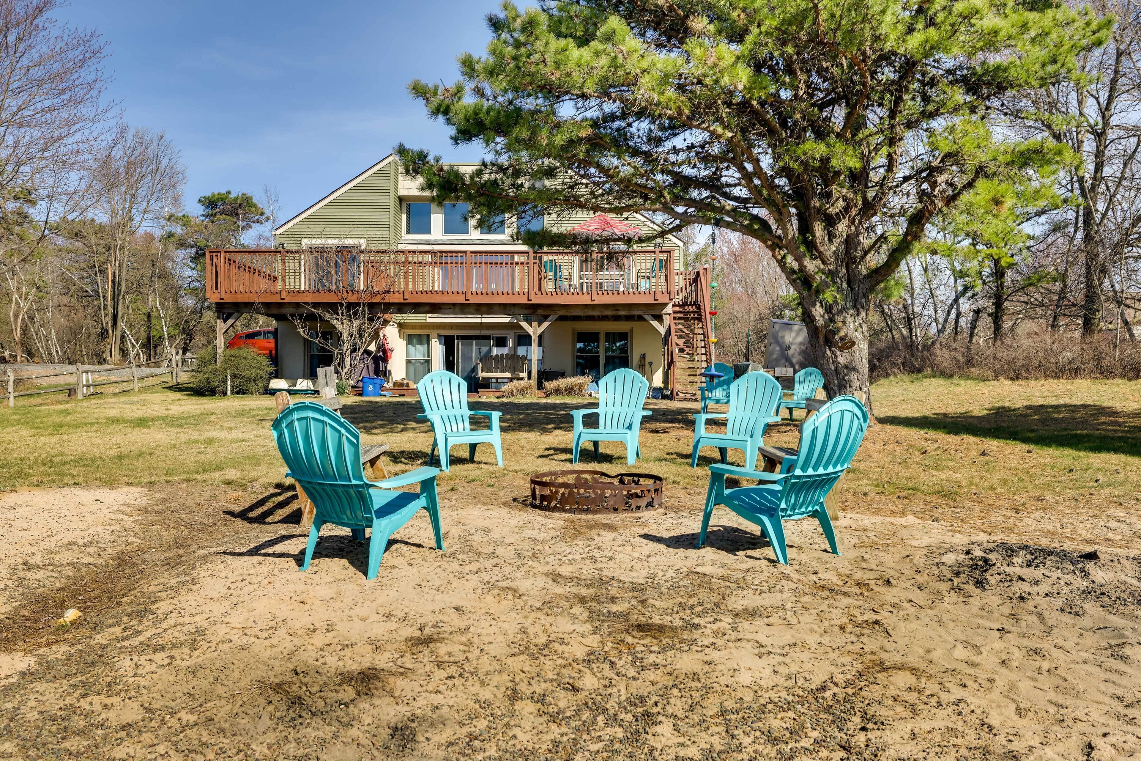 A house with a deck, outdoor seating, and a fire pit.