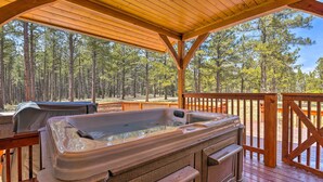 A hot tub on a wooden deck with a view of a forest. - Grand Angel Fire Retreat w/ Hot Tub & Fire Pit! (Angel Fire)