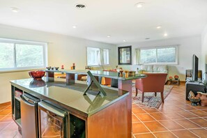 A modern kitchen with a central island, built-in appliances, and large windows providing natural light. - Contemporary Cincinnati Apt w/ Wifi, Near Kenwood! (Cincinnati)