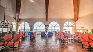 A spacious indoor area with a high ceiling, large arched windows, and a brick floor. - Private Balcony w/ Views: Oceanfront Cancun Condo! (Cancun)