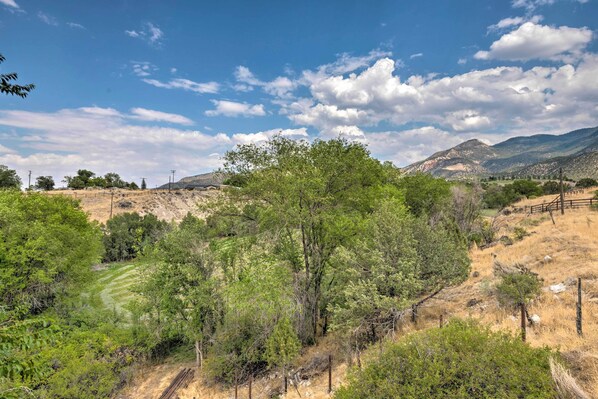A mountainous landscape with a clear sky, trees, and a fenced area. - Secluded Sterling Abode: Near Palisade State Park! (Sterling)