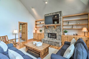 Una sala de estar acogedora con chimenea de piedra, estanterías de madera y asientos cómodos.