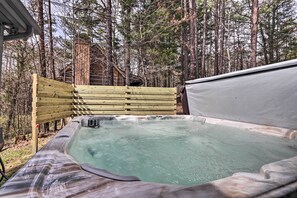 A hot tub in a forested area with a wooden deck and a cabin in the background. - Pigeon Forge Cabin w/ Hot Tub, 12 Mi to Dollywood! (Sevierville)