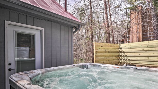 Ein Whirlpool neben einer Holzterrasse und ein Schuppen mit Metalldach.