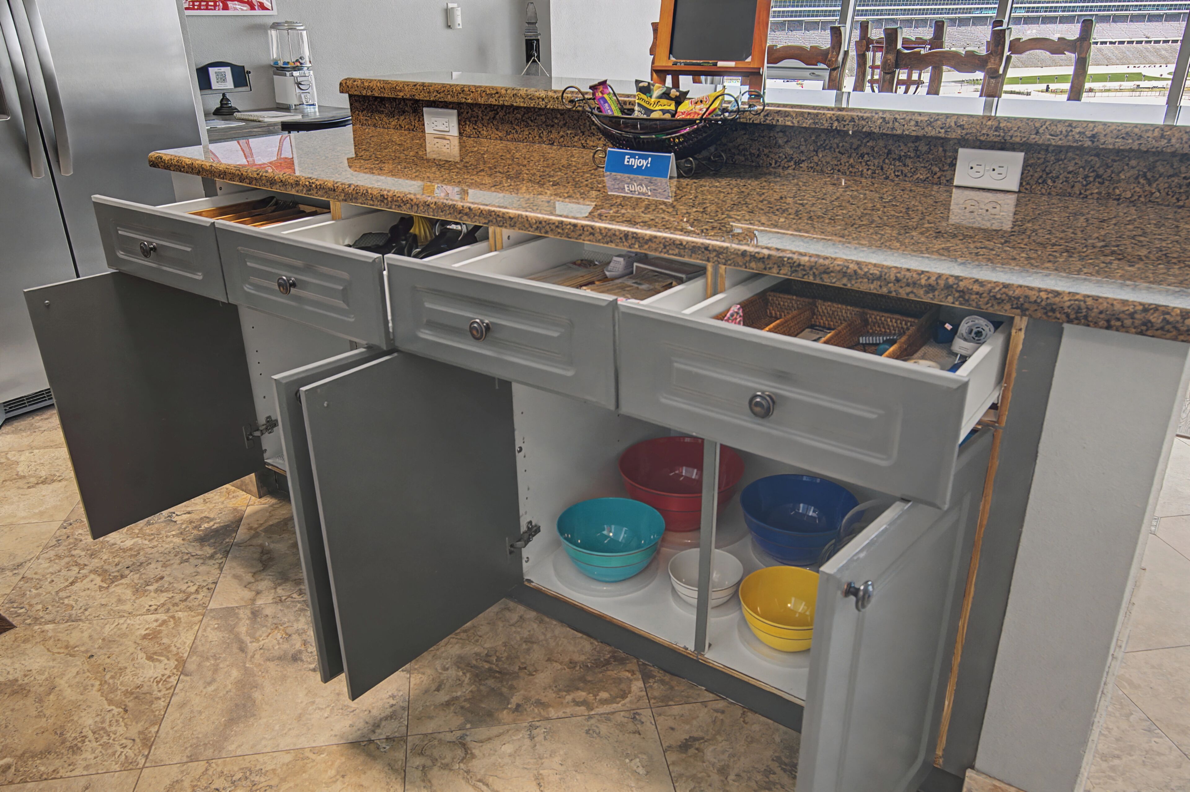 A kitchen with open drawers, a countertop, and a view of an outdoor area.