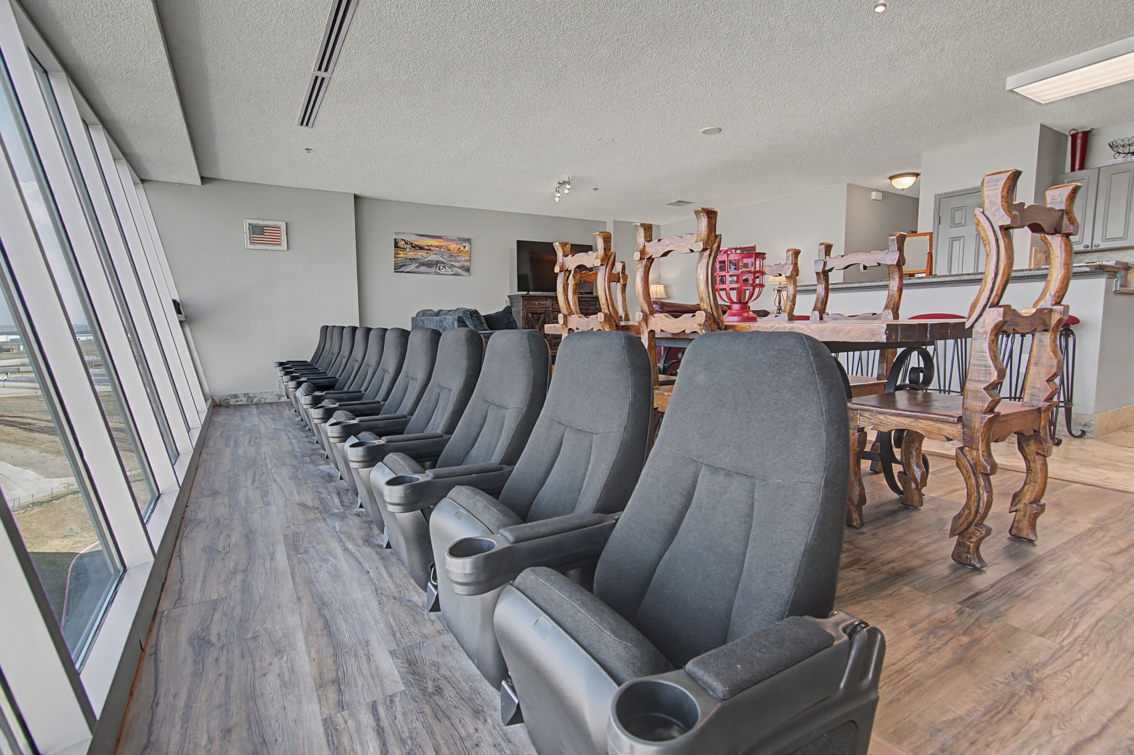 Un salón de conferencias con filas de sillas, una mesa de madera y un ventanal con vistas.