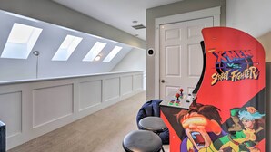 Un couloir avec une porte, un plafond doté de lucarnes et une console de jeux.